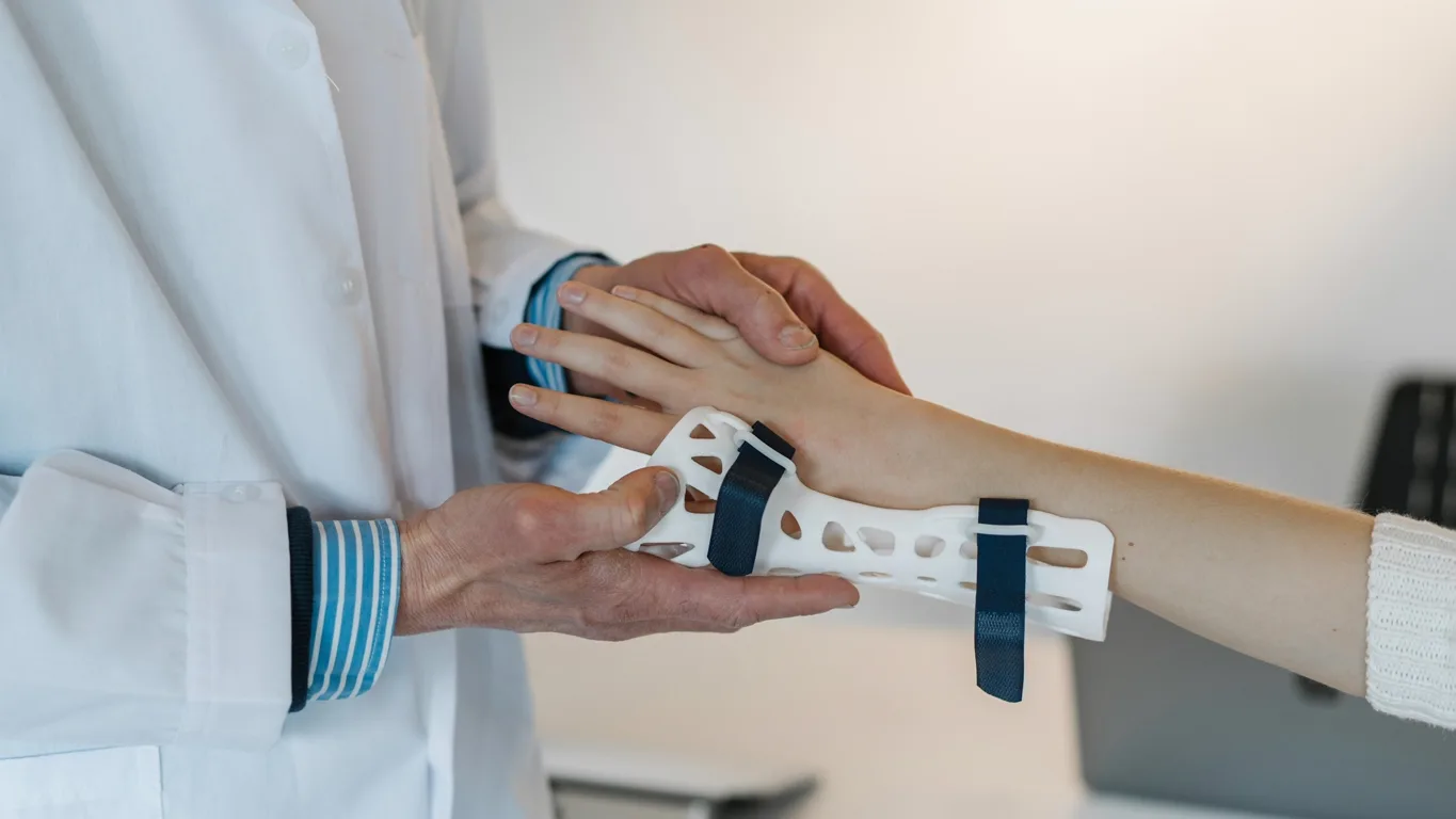 A clinician fitting a wrist splint on a patient.