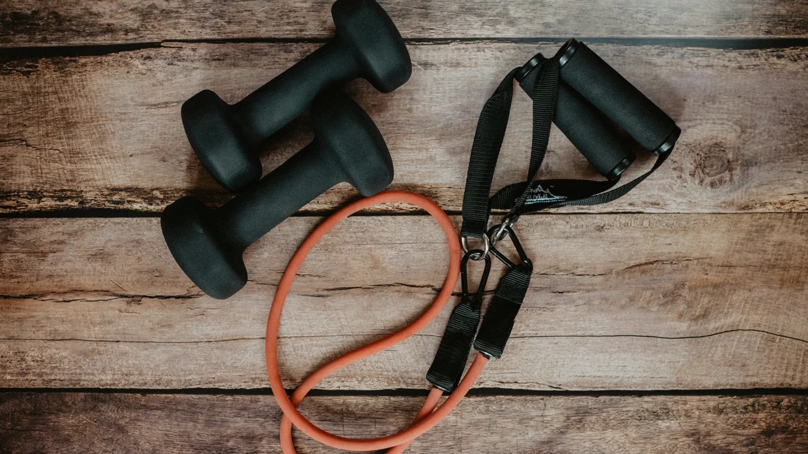 Resistance bands, weights and recovery tools arranged on a flat surface.